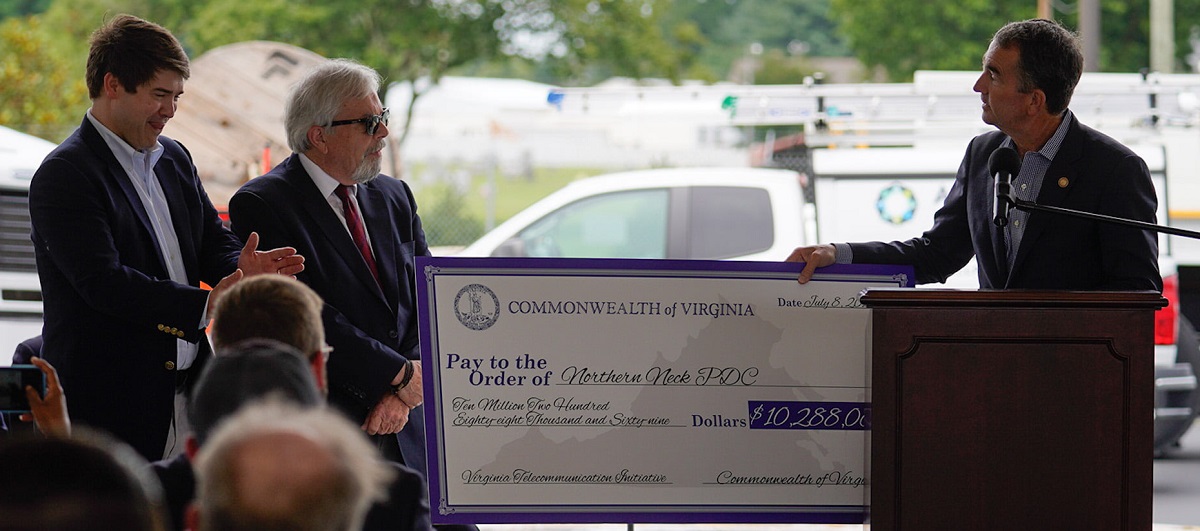 Governor Ralph Northam presenting a check from the Virginia Telecommunication Initiative (VATI) for $10,288,069 to Jerry W. Davis, Executive Director of the Northern Neck Planning District Commission, with Jimmy Carr, CEO of All Points Broadband, standing next to Davis.